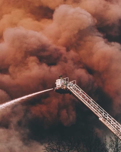 Firefighter using a hose on an extended ladder