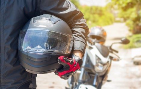 biker holding a motorcycle helmet