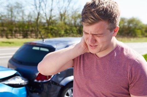 man rubbing his neck after a serious car crash
